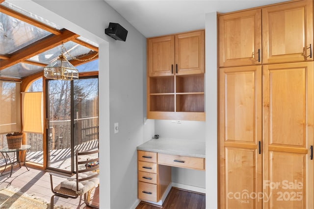 interior space with a chandelier, built in desk, and light hardwood / wood-style flooring