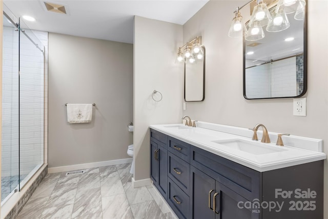 bathroom featuring vanity, toilet, and a shower with door