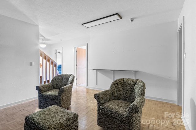 sitting room featuring parquet floors and a textured ceiling