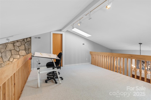 office featuring light colored carpet, vaulted ceiling with skylight, and track lighting