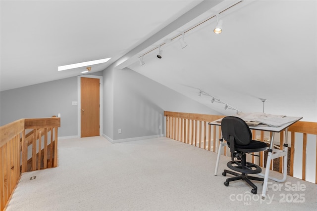 carpeted office featuring lofted ceiling with skylight and rail lighting