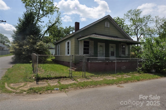 529 Gage St, Chester, SC 29706 - view of front of house featuring a gate, a fenced front yard, a chimney, and covered porch