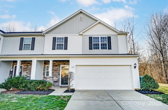 view of front of home featuring a porch, stone siding, driveway, and an attached garage