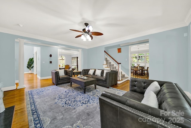 living room with hardwood / wood-style flooring, ornamental molding, and decorative columns