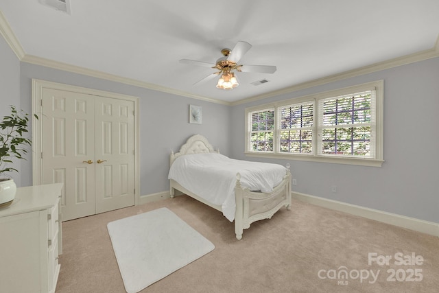 carpeted bedroom featuring ceiling fan, ornamental molding, and a closet