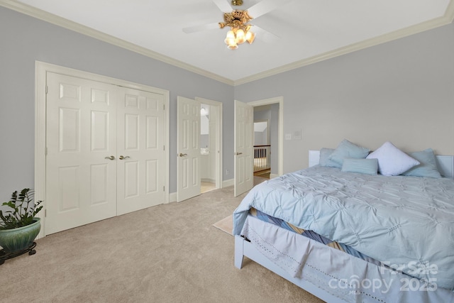 carpeted bedroom with ceiling fan, ornamental molding, and a closet