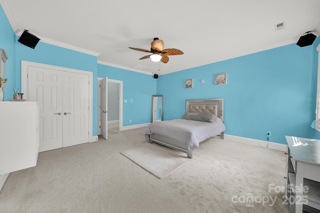 bedroom featuring ceiling fan, a closet, ornamental molding, and light carpet