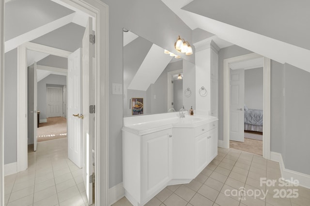 bathroom featuring tile patterned flooring, vanity, and lofted ceiling