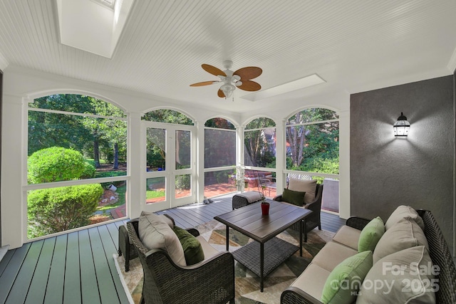 sunroom with ceiling fan, a skylight, and a wealth of natural light