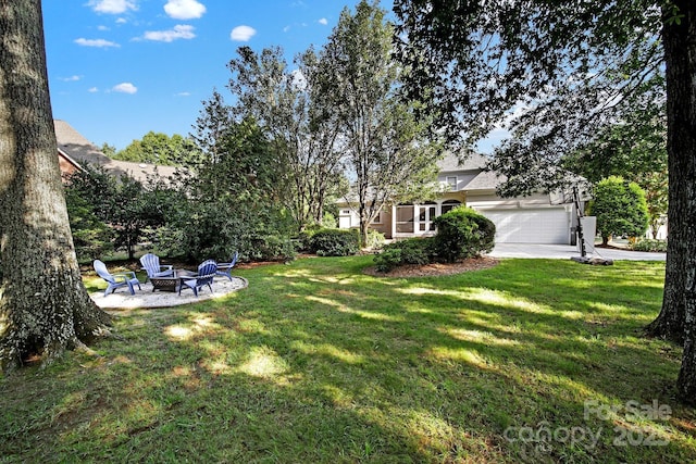 view of yard with an outdoor fire pit and a garage