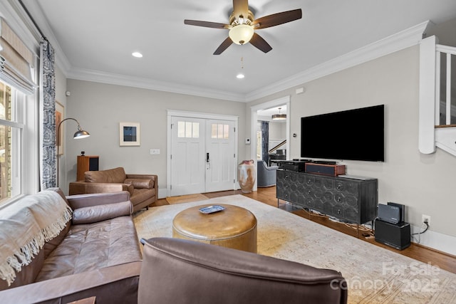 living room with crown molding, ceiling fan, and light hardwood / wood-style flooring