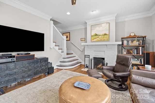 living room featuring ornamental molding, a brick fireplace, and hardwood / wood-style floors