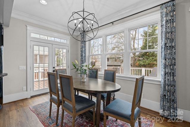 dining room featuring a notable chandelier, crown molding, french doors, and hardwood / wood-style flooring