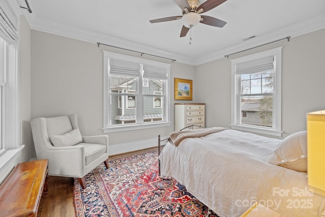 bedroom with crown molding, ceiling fan, and dark hardwood / wood-style flooring