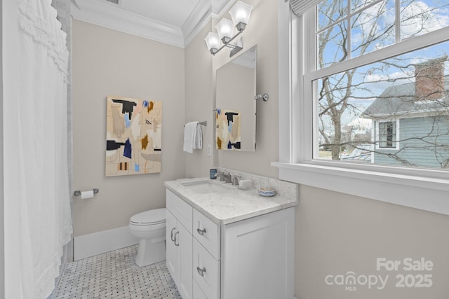 bathroom with ornamental molding, toilet, vanity, and a wealth of natural light