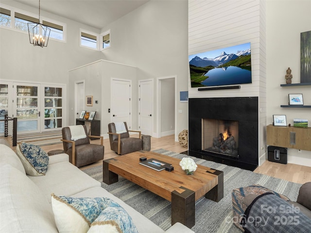 living room featuring hardwood / wood-style flooring, an inviting chandelier, and a high ceiling