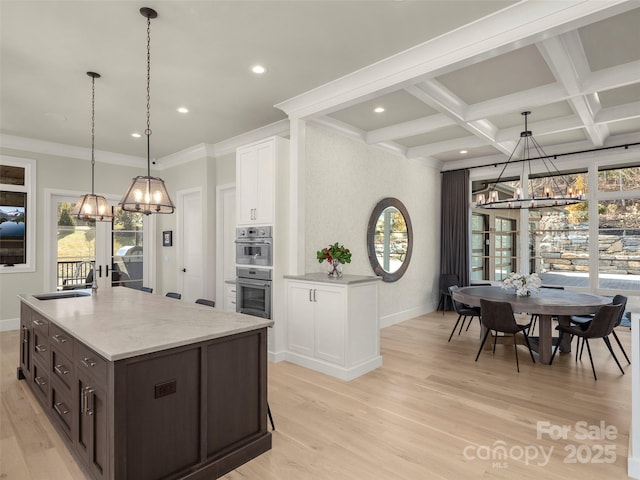 kitchen with double oven, decorative light fixtures, white cabinets, a notable chandelier, and dark brown cabinetry