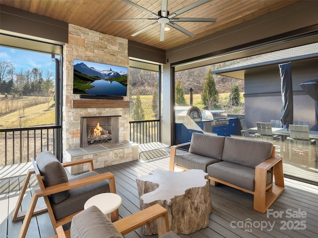 sunroom / solarium featuring an outdoor stone fireplace, a healthy amount of sunlight, ceiling fan, and wood ceiling