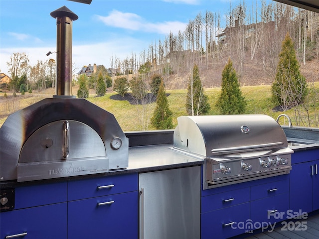 view of patio featuring an outdoor kitchen and a grill