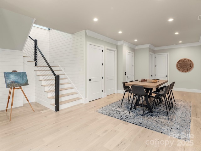 dining space featuring crown molding, a skylight, and light hardwood / wood-style floors