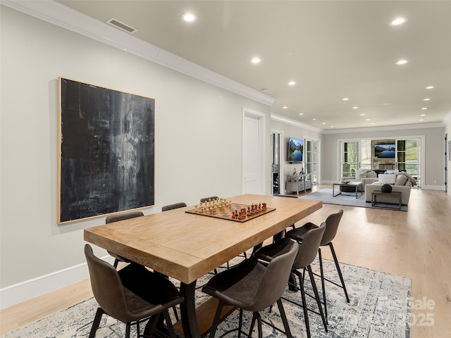 dining area featuring light hardwood / wood-style flooring and ornamental molding