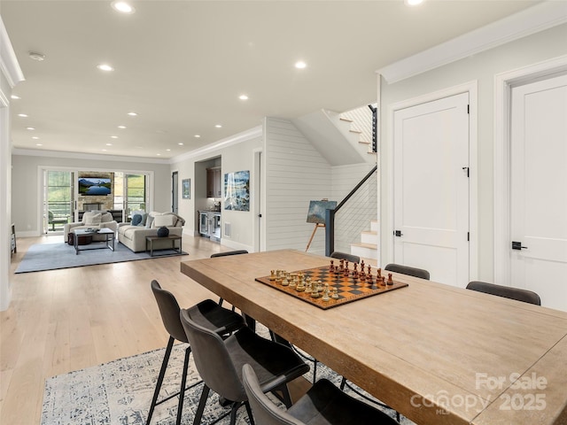 dining space with crown molding and light hardwood / wood-style flooring