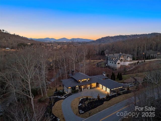 aerial view at dusk featuring a mountain view