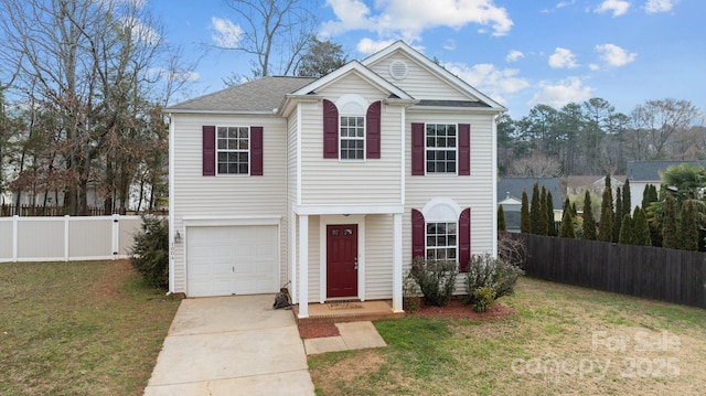 traditional home featuring a front yard, fence, driveway, and an attached garage