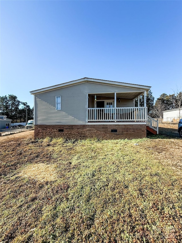 exterior space featuring a porch and a lawn