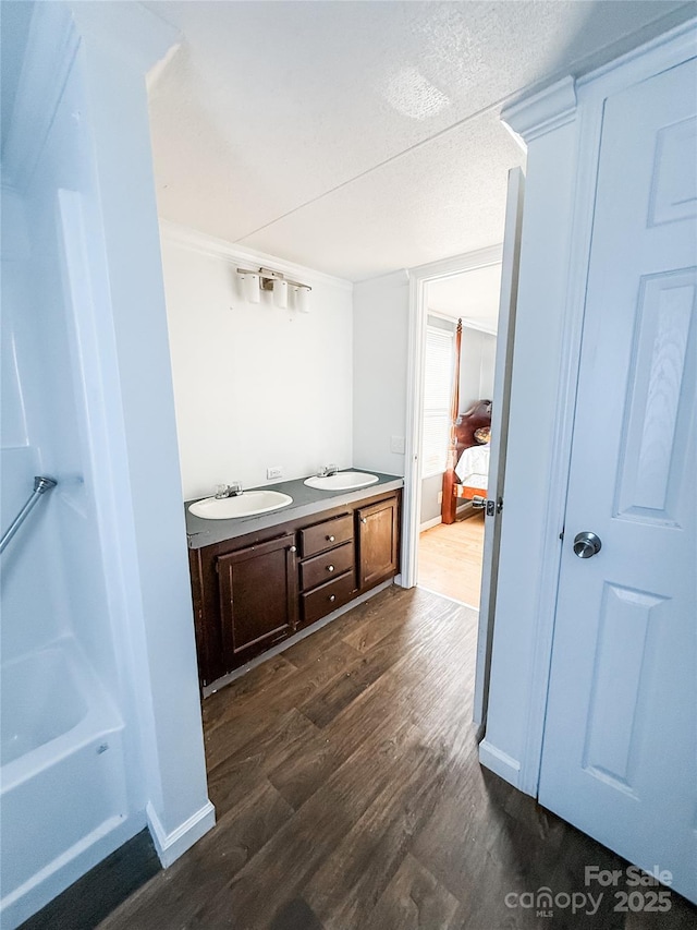 bathroom with wood-type flooring, vanity, and a textured ceiling