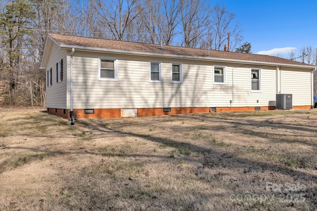 view of side of property with central AC unit and a lawn