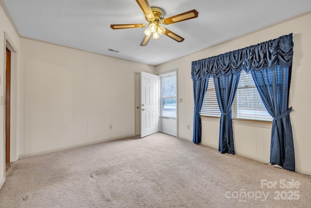 spare room with light carpet, ceiling fan, and a textured ceiling