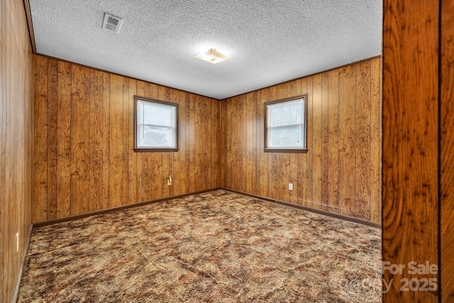 carpeted spare room featuring a textured ceiling