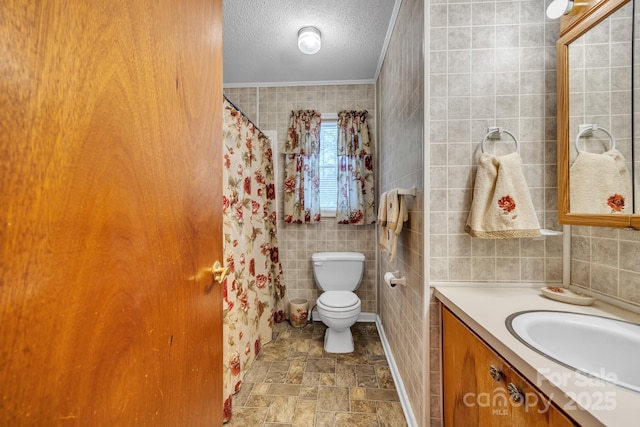 bathroom featuring tile walls, vanity, ornamental molding, a textured ceiling, and toilet