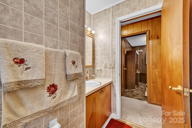 bathroom featuring vanity, tile walls, and crown molding