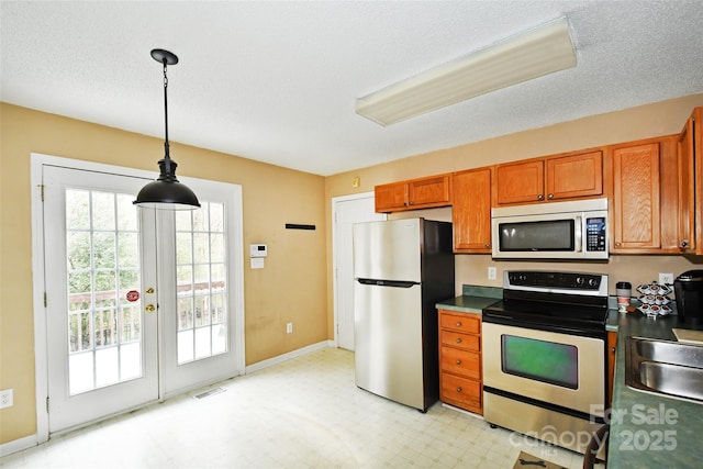 kitchen with sink, decorative light fixtures, stainless steel appliances, and a textured ceiling