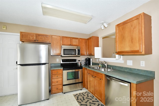 kitchen featuring sink, a textured ceiling, and appliances with stainless steel finishes