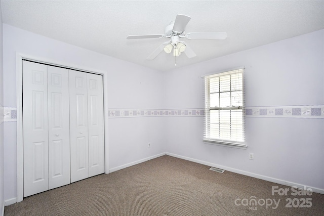 unfurnished bedroom with carpet floors, a closet, and ceiling fan