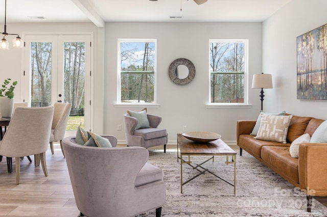 living area with a healthy amount of sunlight, light wood-style flooring, and baseboards