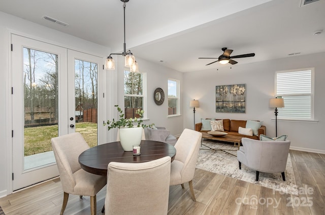 dining space featuring light wood-style floors, visible vents, and plenty of natural light