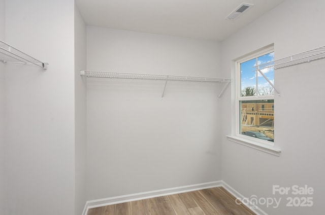 walk in closet featuring visible vents and wood finished floors