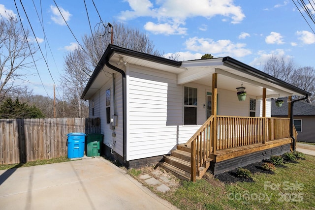 view of front facade featuring a porch, fence, and a ceiling fan