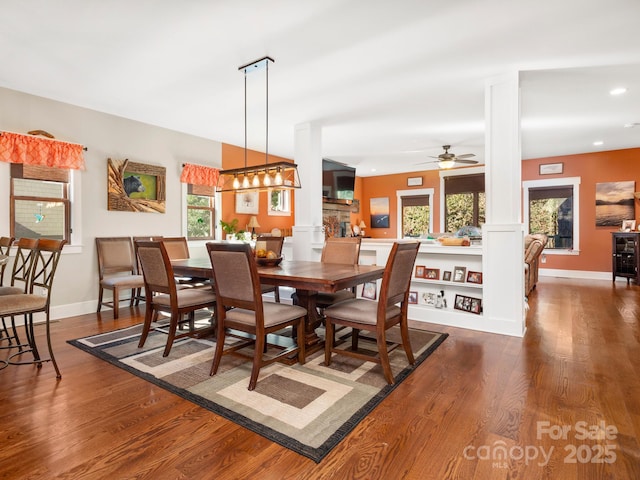 dining room with ceiling fan, dark hardwood / wood-style floors, and decorative columns