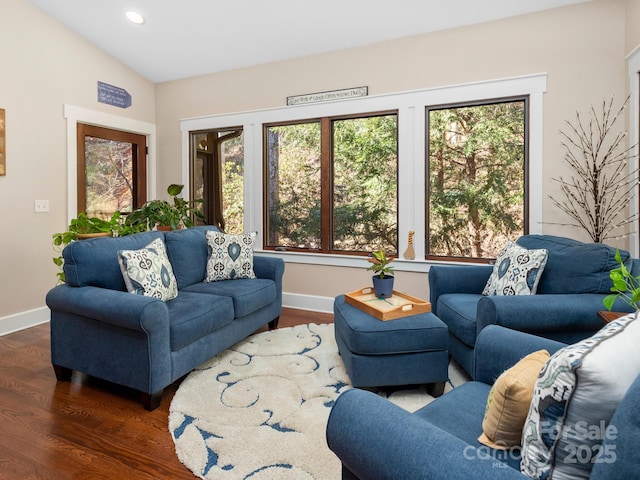 living room featuring dark wood-type flooring, vaulted ceiling, and a wealth of natural light