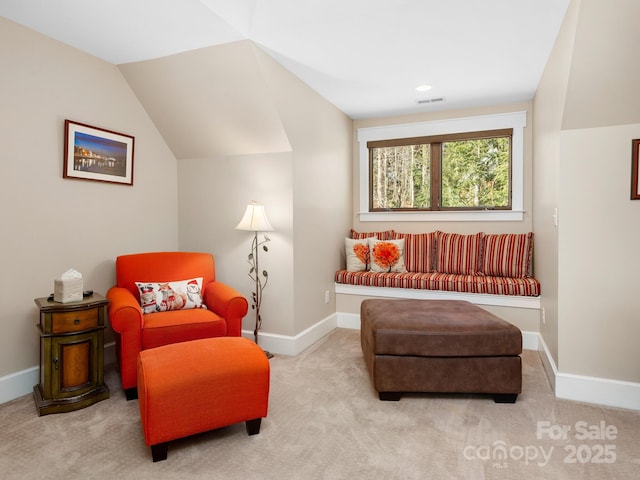 living area with lofted ceiling and light carpet