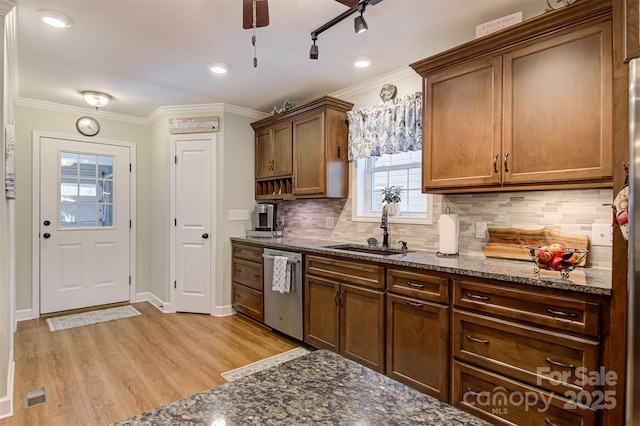 kitchen with sink, crown molding, light hardwood / wood-style flooring, dishwasher, and dark stone counters