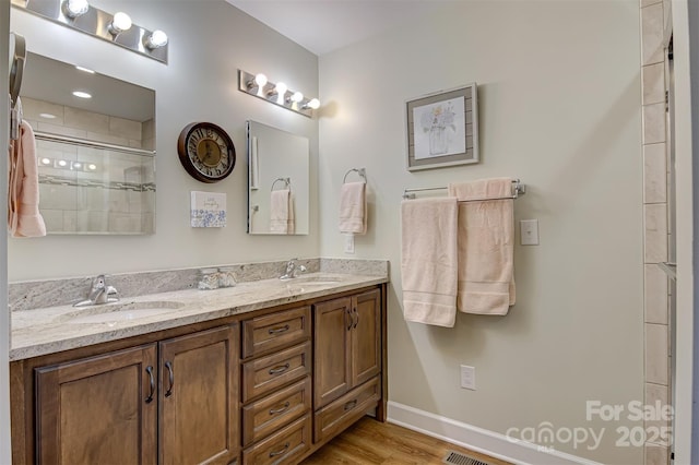 bathroom featuring vanity, an enclosed shower, and wood-type flooring