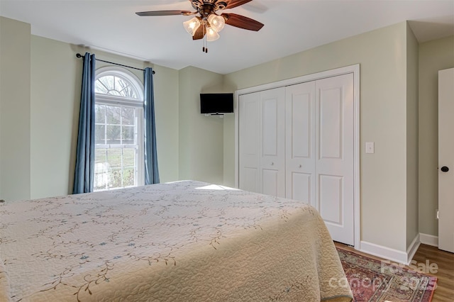 bedroom with hardwood / wood-style flooring, ceiling fan, and a closet