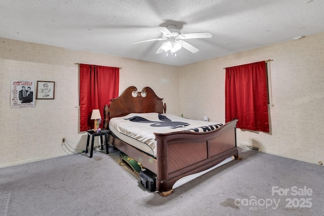 carpeted bedroom featuring ceiling fan and a textured ceiling