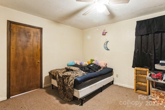 bedroom featuring ceiling fan, a textured ceiling, and carpet flooring